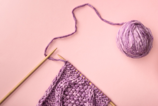 pose plate avec fil violet et aiguilles à tricoter sur la surface rose
 - Photo, image