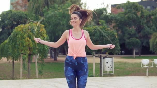 Ajuste hermosa mujer con saltar la cuerda en un parque
 - Metraje, vídeo