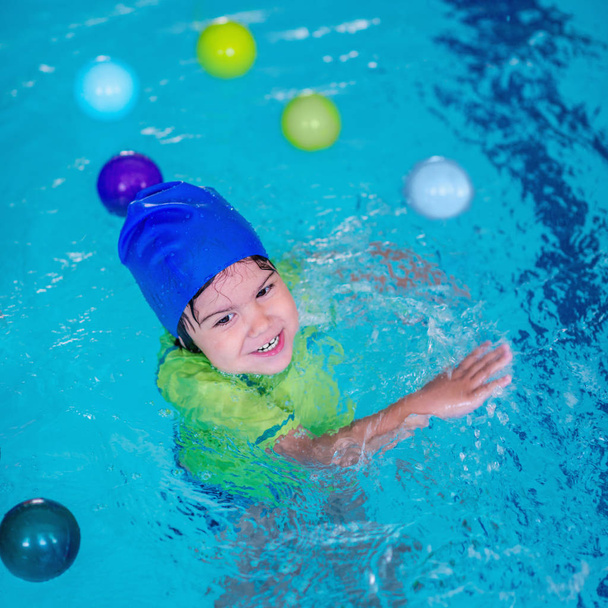 Criança bonito se divertindo em uma piscina
 - Foto, Imagem