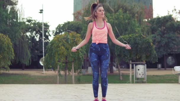Ajuste mulher bonita com corda de salto em um parque
 - Filmagem, Vídeo