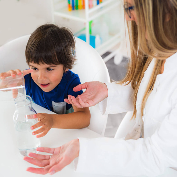 Child psychology, toddler doing tests with water and glasses - Photo, Image