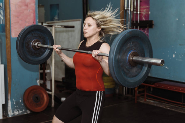 Femmina in allenamento di sollevamento pesi in palestra
   - Foto, immagini