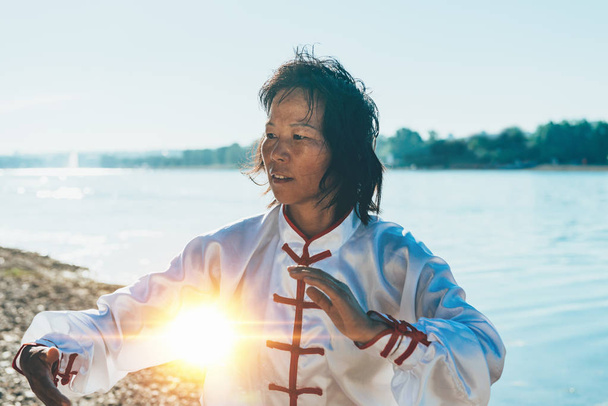 Tai Chi, a tó mellett ellátó nő - Fotó, kép