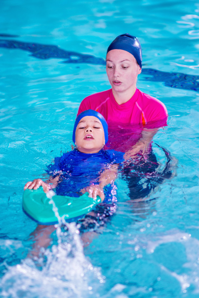 Мальчик на уроке плавания с инструктором
 - Фото, изображение