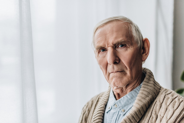 zdenerwowany mężczyzna na emeryturze z siwe włosy patrząc na kamery  - Zdjęcie, obraz