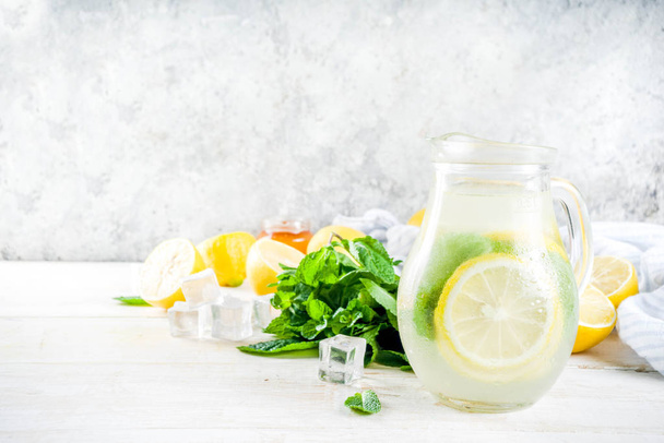 Homemade sour cocktail lemonade, with fresh lemons, mint and honey, white wooden background copy space - Фото, зображення
