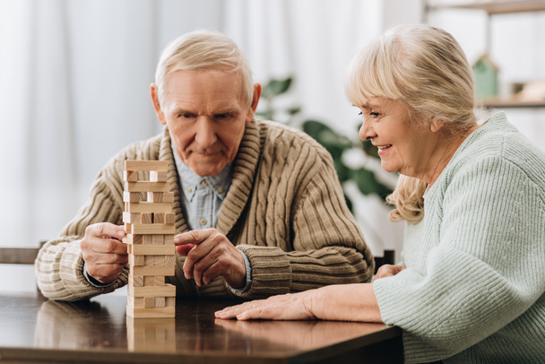 retired husband and wife playing jenga game on table - Foto, Bild