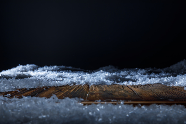 brown wooden board covered with snow on black - 写真・画像