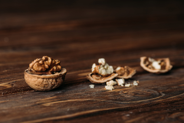 walnoten in notedoppen als dementie symbool op houten tafel  - Foto, afbeelding
