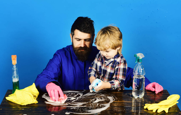 Dad and son at table near cleaning props. - Foto, Bild