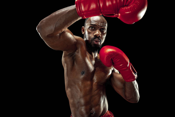 Hand of boxer over black background. Strength, attack and motion concept - 写真・画像