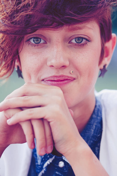 Fashionable teenage hipster girl with lip ring piercing and spiked trendy accessories posing.   - 写真・画像