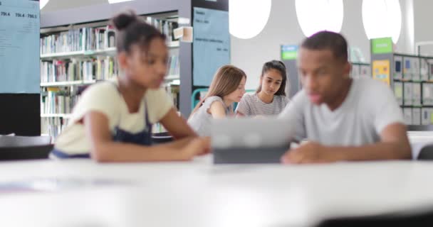 Estudantes do ensino médio estudando juntos em uma biblioteca com um tablet digital
 - Filmagem, Vídeo