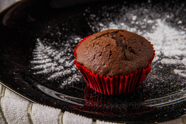 Čokoládové muffiny na tmavém pozadí s moučkovým cukrem - Fotografie, Obrázek