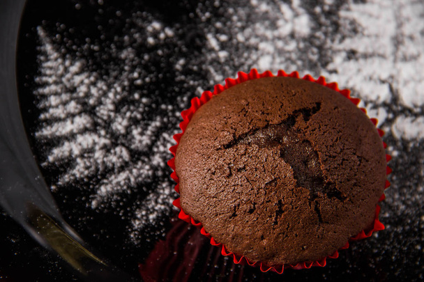 Шоколадні кекси на темному тлі з глазурованим цукром
 - Фото, зображення