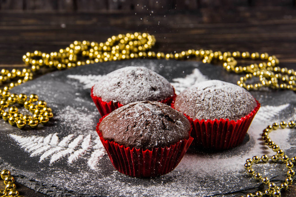 粉砂糖と暗い背景にチョコレートのマフィン - 写真・画像