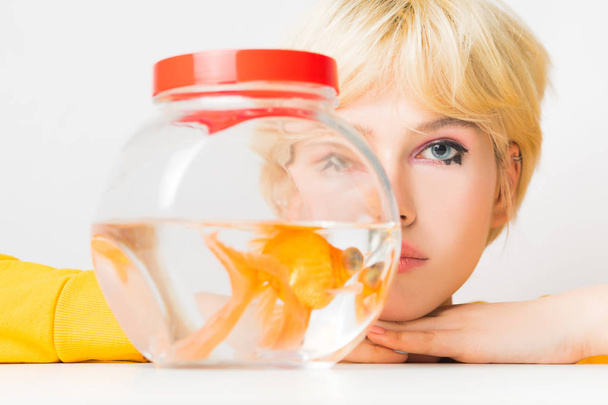 Portrait of a beautiful girl with a goldfish in an aquarium. - Фото, зображення