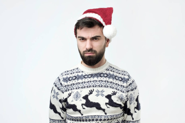 O onun hediyeler gibi değil çünkü kırmızı Noel şapka giyen İspanyol adam üzgün. - Fotoğraf, Görsel