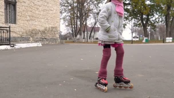 girl ride in autumn park on rollerblades, sport and recreations. - Footage, Video