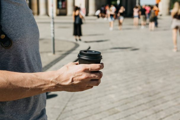 Closeup muže na ulici, drží v ruce kávu nebo jiný nápoj s sebou. - Fotografie, Obrázek