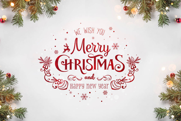Creatieve badrand van Kerstmis fir takken op wit papier achtergrond met rode decoratie, dennenappels. Kerstmis en Nieuwjaar thema, bokeh. Plat lag, top uitzicht - Foto, afbeelding