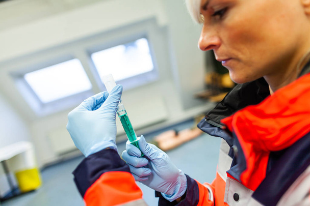 paramédico alemán recoge una jeringa para un paciente
 - Foto, Imagen