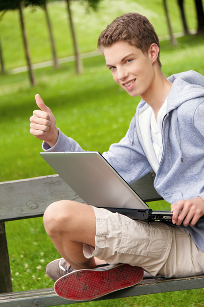 Teenager with laptop outdoors - Фото, зображення