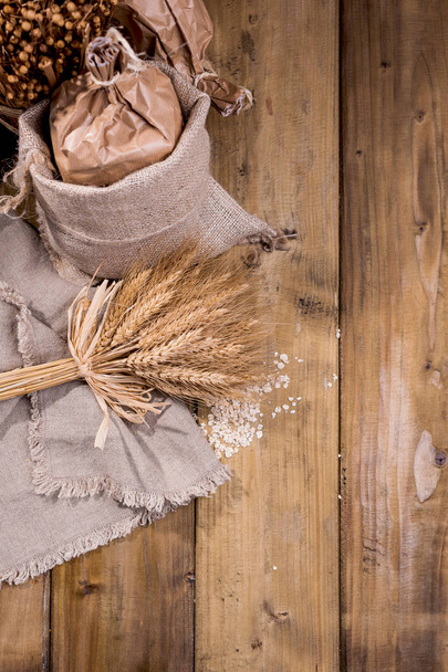 Homemade oatmeal cake for breakfast. Flour in a bag and a bouquet of wheat ears. Free space for text. Vintage photo - Fotoğraf, Görsel