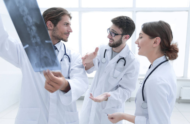 Three confident doctors examine an x-ray - Φωτογραφία, εικόνα
