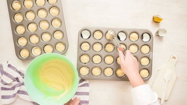 Flat lay. Scooping vanilla cupcake batter into cupcake liners. - Foto, Imagen