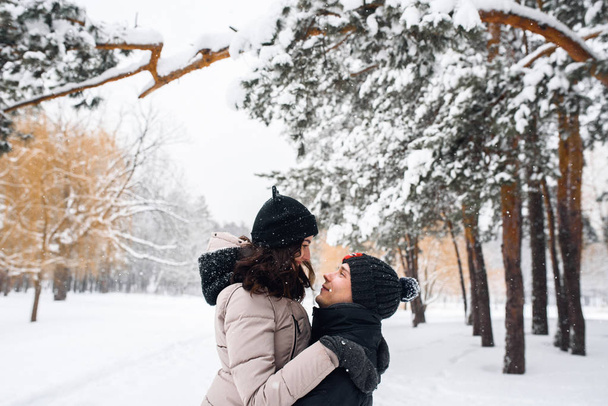 Couple in love walking in the snowy woods - Фото, изображение