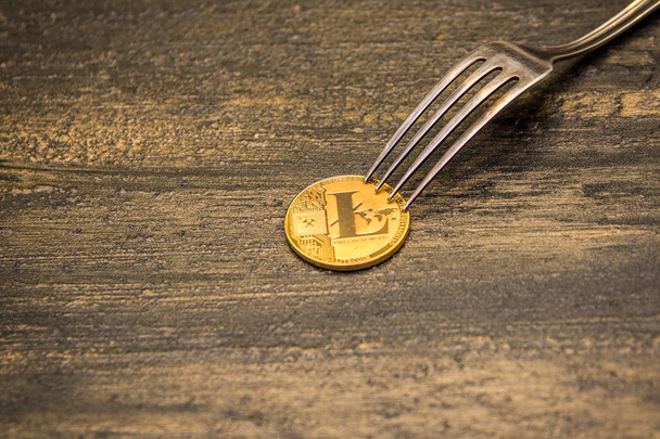 golden Litecoin and silver fork on old background - Fotografie, Obrázek