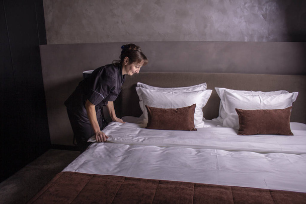 Otel odasında çarşaf yastık kurma otel hizmetçisi - Fotoğraf, Görsel