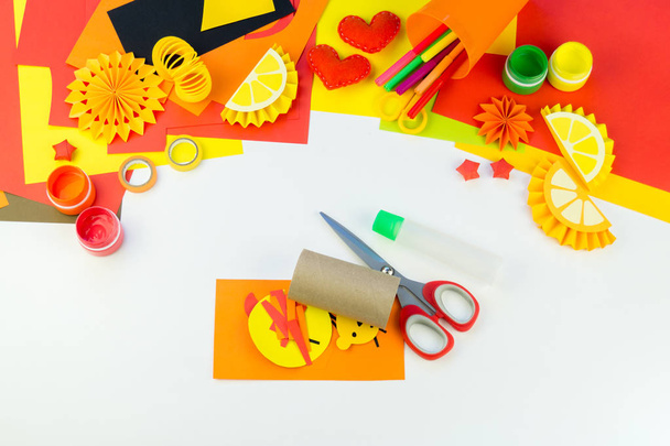 The child is doing paper craft lion the workshop. An animal from hot Africa. Children's hand. Material for creativity. White background. - Foto, Imagem