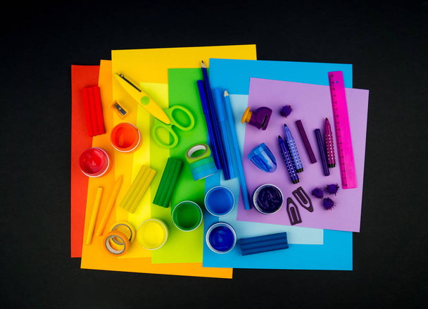 School accessories are laid out in the form of a rainbow. Black background.Happy back to school student. Art and crafts for kids. Child learning rainbow colors, alphabet letters and numbers. - Fotografie, Obrázek