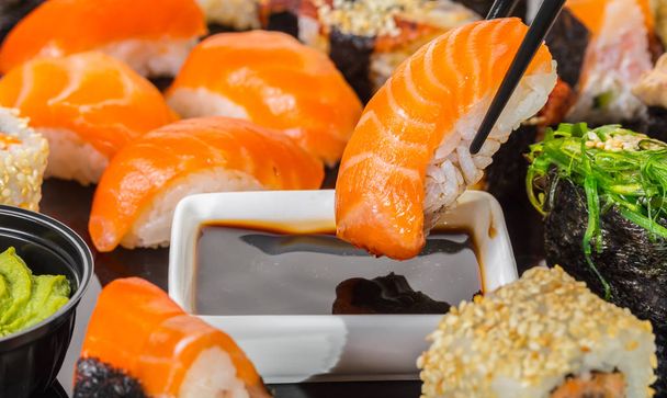 Japanese cuisine, sushi with salmon in soy sauce - Фото, зображення