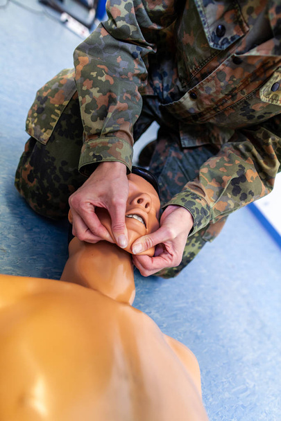 Paramedical soldier practices a medical training on a puppet - Fotó, kép