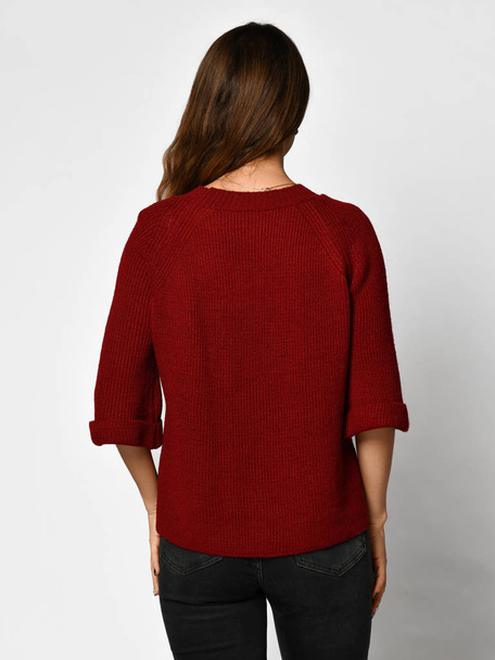 Young beautiful woman posing in new casual red blouse sweater backside rear view - Foto, imagen