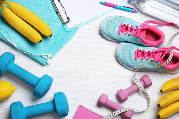 Flat lay composition with sport items, healthy food and space for text on wooden background. Weight loss concept - 写真・画像