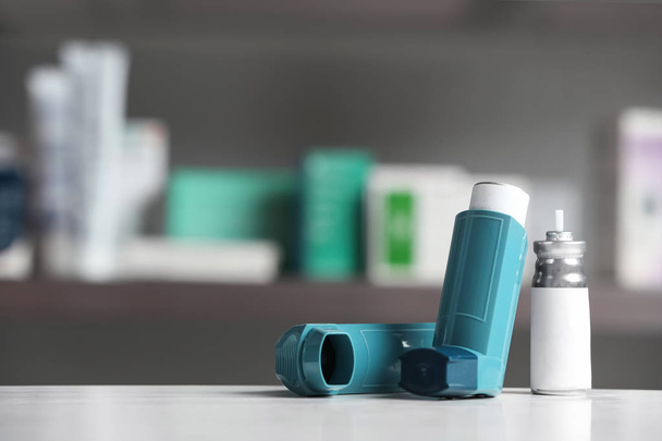 Asthma inhalers on table against blurred background. Space for text - Foto, Imagem