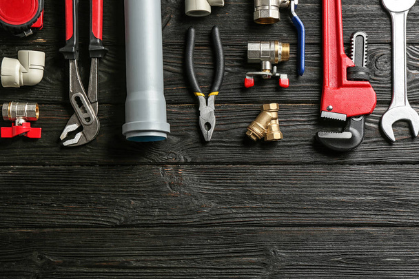 Flat lay composition with plumber's tools and space for text on wooden background - Foto, immagini