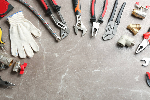 Flat lay composition with plumber's tools and space for text on grey background - 写真・画像