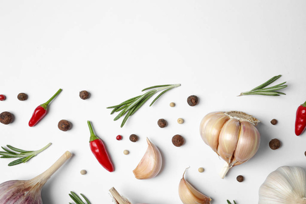 Composition with garlic, rosemary and peppers on white background, top view. Space for text - Photo, image