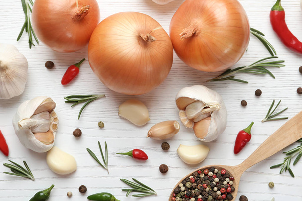 Composition with garlic, peppers and onions on white wooden background, flat lay - 写真・画像