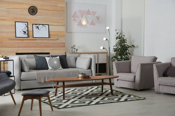 Stylish living room interior with comfortable couch and decorative elements - Fotó, kép