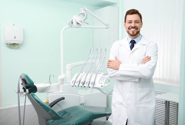 Professional male dentist in white coat at workplace. Space for text - Foto, imagen
