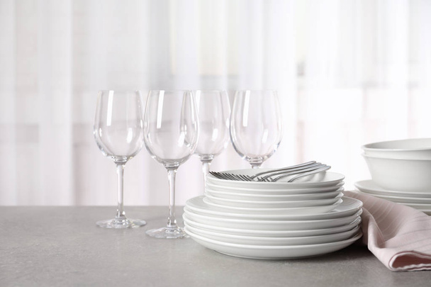 Set of clean dishes on table against blurred background - Foto, afbeelding