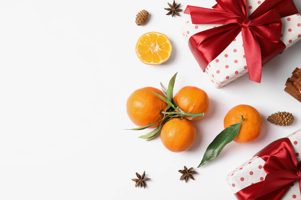 Christmas composition with gift boxes, ripe tangerines and space for text on white background, flat lay - Valokuva, kuva