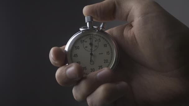 Close up Mans Hand starting up a Stopwatch at gray background 4K, 10 BIT, 4:2:2 - Footage, Video
