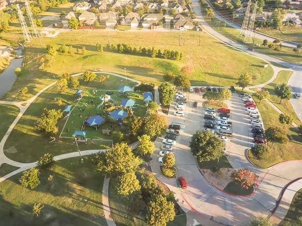 Aire de jeux vue de dessus près du quartier résidentiel avec lignes électriques aériennes à Carrollton, banlieue Dallas, Texas, États-Unis. Espace vert récréatif gazon synthétique de taille, aire de pique-nique couverte au coucher du soleil
 - Photo, image